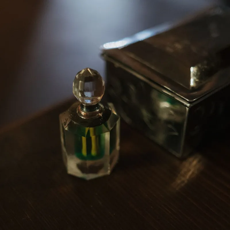 Crystal perfume bottle beside an ornate gift box