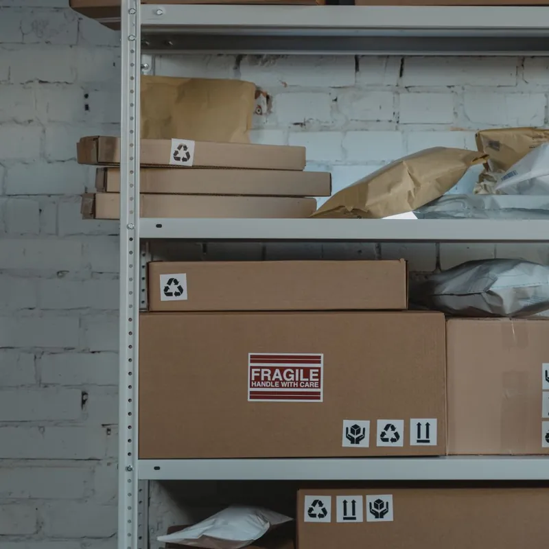 Small Texas business fulfillment shelf with packed shipping boxes and mailers